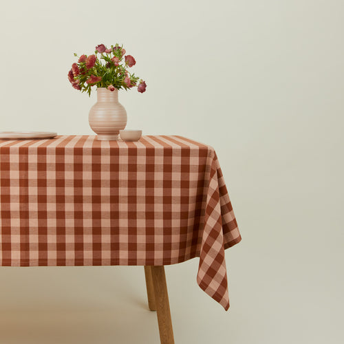 Essential Gingham tablecloth in blush/terracotta on a table with florals.