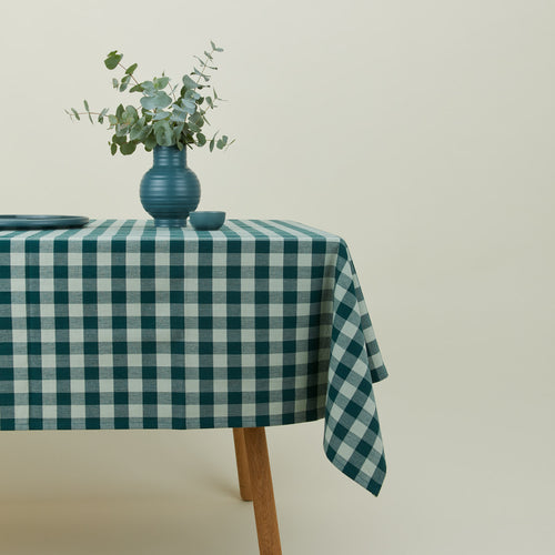Essential Gingham tablecloth in sky/peacock on a table with florals.