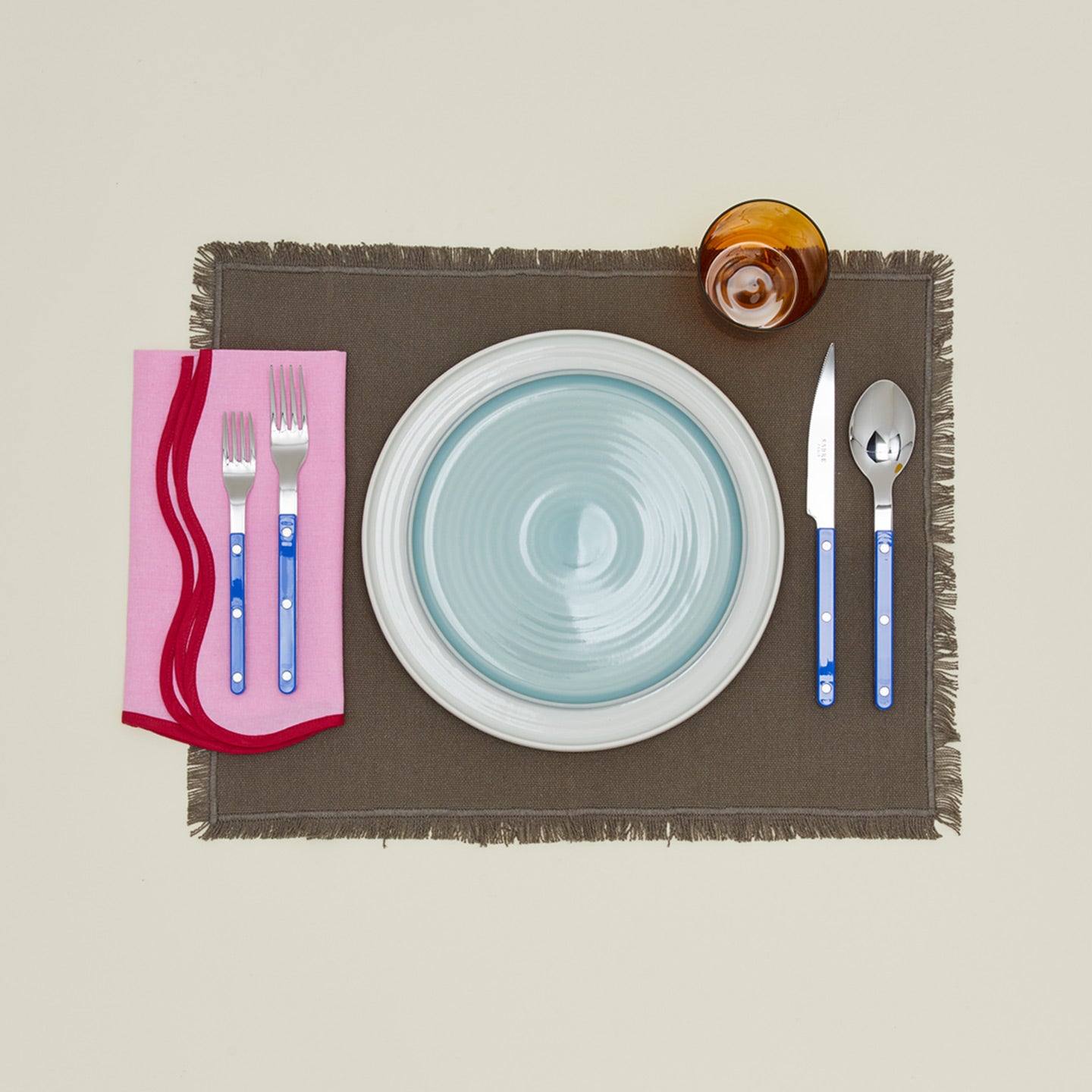 Modafleur scalloped napkin in shrimp with place setting on placemat
